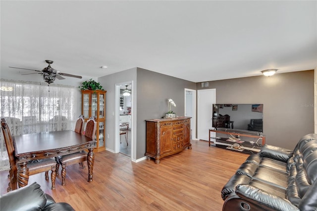 living room featuring ceiling fan and light hardwood / wood-style flooring