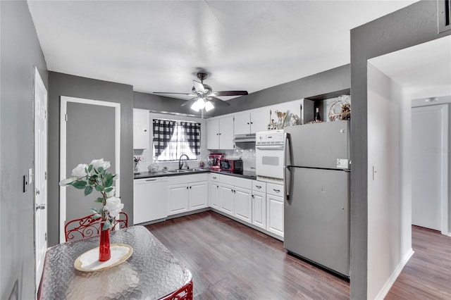 kitchen featuring white appliances, sink, ceiling fan, and dark hardwood / wood-style flooring