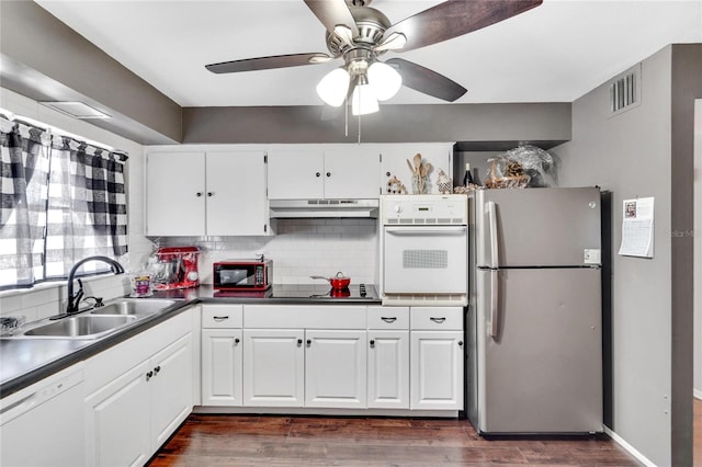 kitchen featuring black appliances, dark hardwood / wood-style floors, backsplash, sink, and ceiling fan