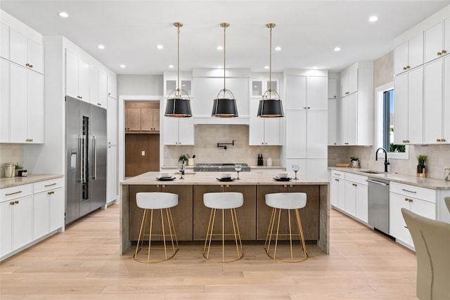 kitchen with stainless steel appliances, a center island with sink, tasteful backsplash, and sink