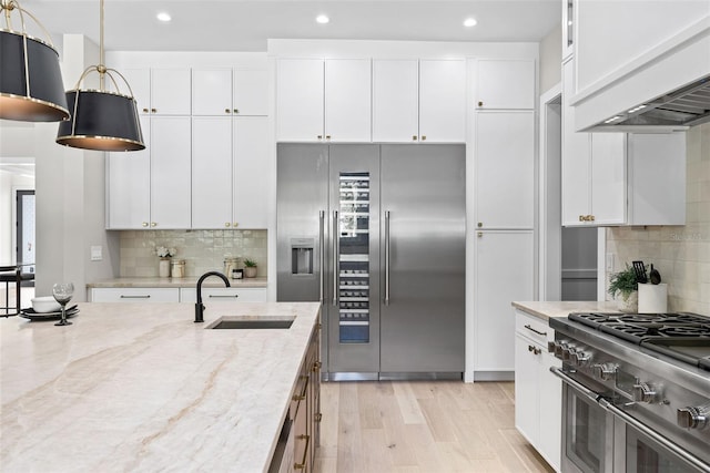 kitchen featuring white cabinets, light stone countertops, and high quality appliances