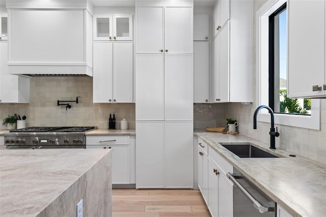 kitchen featuring sink, decorative backsplash, white cabinetry, and appliances with stainless steel finishes