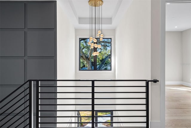 stairs featuring an inviting chandelier and wood-type flooring