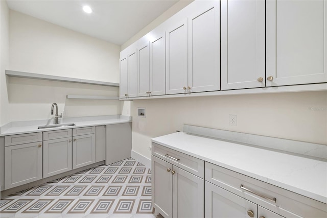 clothes washing area featuring hookup for a washing machine, cabinets, and sink