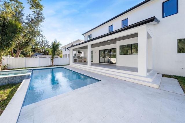 view of swimming pool featuring a patio and exterior kitchen