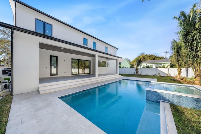 view of swimming pool featuring a patio area and an in ground hot tub