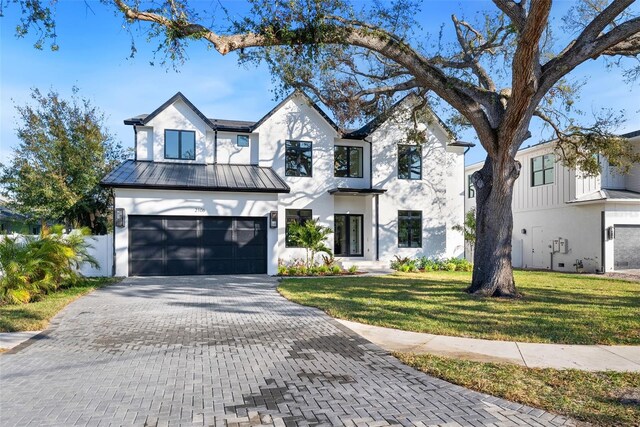 modern inspired farmhouse with a front yard and a garage