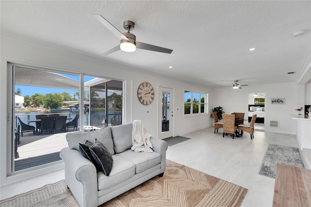 living room featuring a textured ceiling, plenty of natural light, and ceiling fan