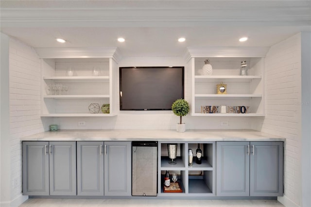 bar featuring built in shelves, gray cabinets, ornamental molding, and brick wall