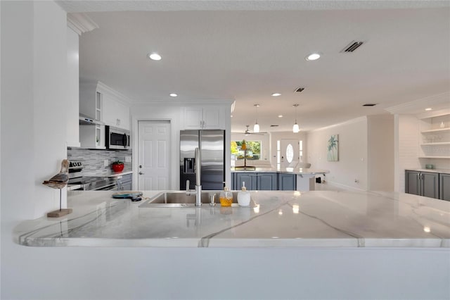 kitchen featuring kitchen peninsula, stainless steel appliances, white cabinetry, and light stone counters