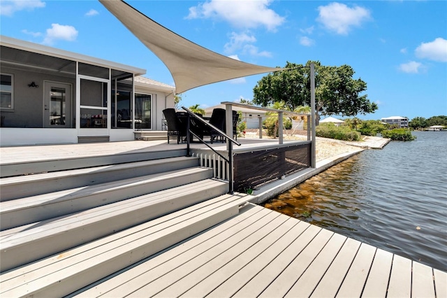 wooden terrace with a water view and a sunroom