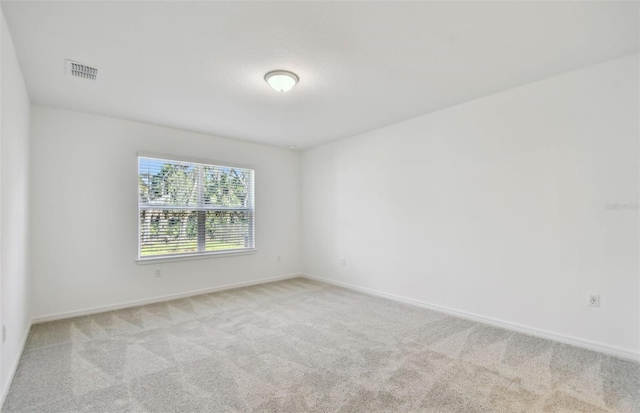 unfurnished room featuring light carpet