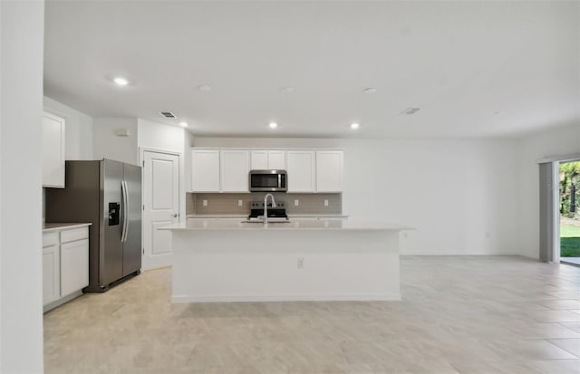 kitchen featuring sink, white cabinetry, stainless steel appliances, and a kitchen island with sink