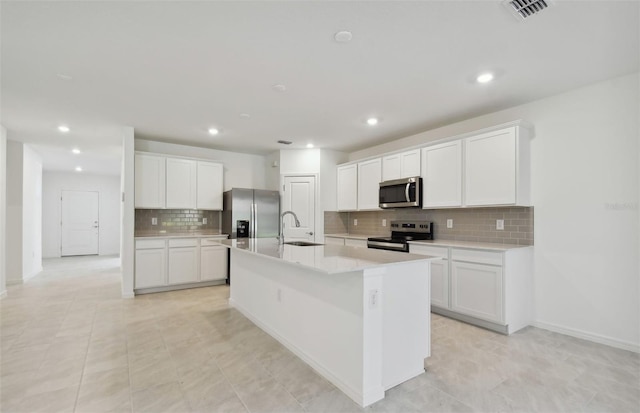 kitchen with white cabinetry, a center island with sink, and appliances with stainless steel finishes