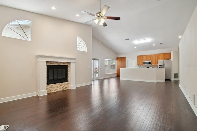 unfurnished living room with dark hardwood / wood-style floors, high vaulted ceiling, and ceiling fan