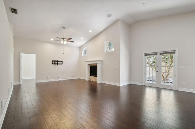 unfurnished living room featuring a high ceiling, dark hardwood / wood-style floors, and ceiling fan