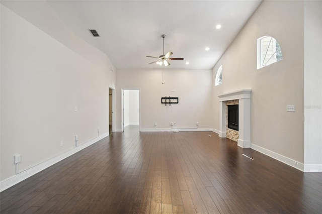 unfurnished living room with ceiling fan, dark hardwood / wood-style flooring, and a high ceiling