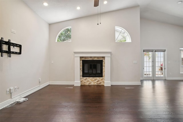 unfurnished living room with dark hardwood / wood-style flooring, high vaulted ceiling, plenty of natural light, and ceiling fan