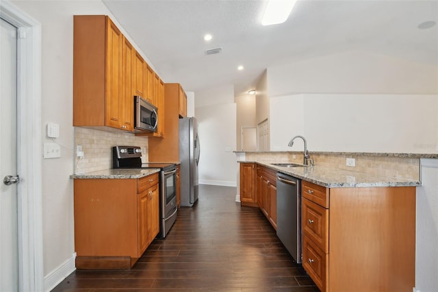 kitchen with sink, stainless steel appliances, light stone counters, dark hardwood / wood-style floors, and lofted ceiling