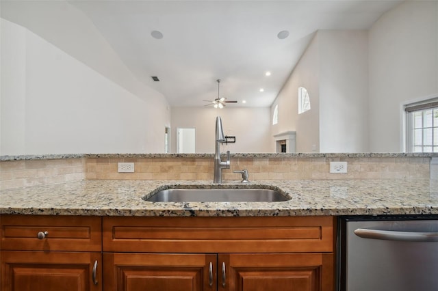 kitchen with dishwasher, light stone countertops, ceiling fan, and sink