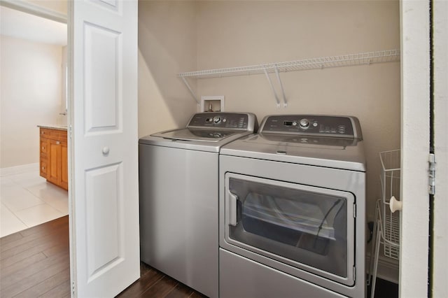 clothes washing area with washer and dryer and dark hardwood / wood-style floors