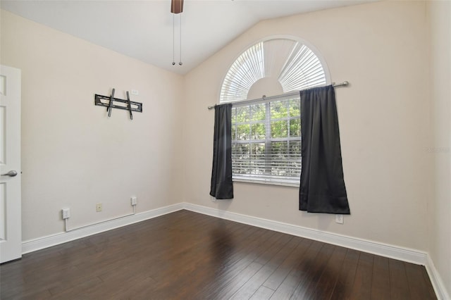 spare room with dark hardwood / wood-style floors, vaulted ceiling, and ceiling fan