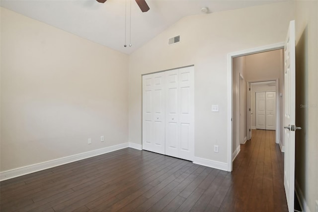 unfurnished bedroom featuring dark hardwood / wood-style flooring, a closet, high vaulted ceiling, and ceiling fan