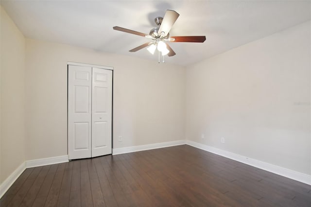 unfurnished bedroom featuring ceiling fan, dark wood-type flooring, and a closet