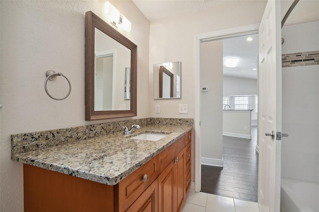 bathroom featuring hardwood / wood-style floors, vanity, and lofted ceiling