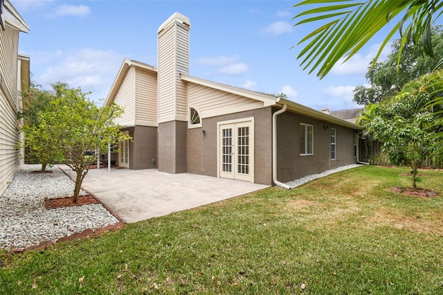 rear view of property with a yard, a patio, and french doors