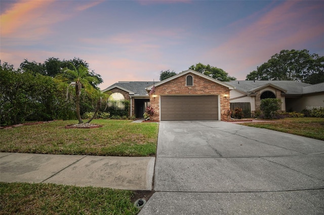 ranch-style house with a yard and a garage