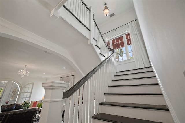 staircase featuring an inviting chandelier