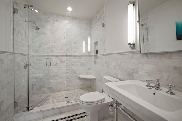 bathroom with toilet, a shower with shower door, sink, and tile walls