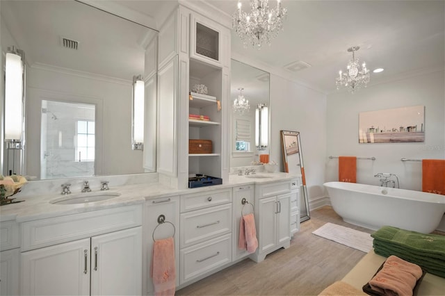 bathroom featuring plus walk in shower, an inviting chandelier, crown molding, vanity, and hardwood / wood-style flooring