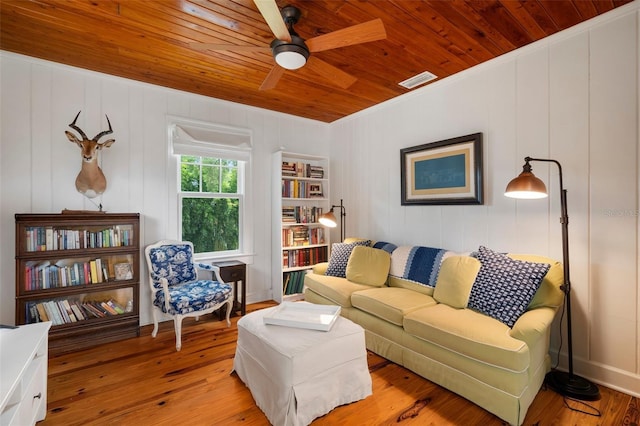 living room featuring built in shelves, ceiling fan, light wood-type flooring, and wood ceiling