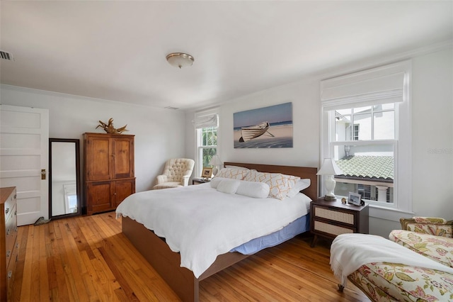 bedroom with light hardwood / wood-style floors and ornamental molding