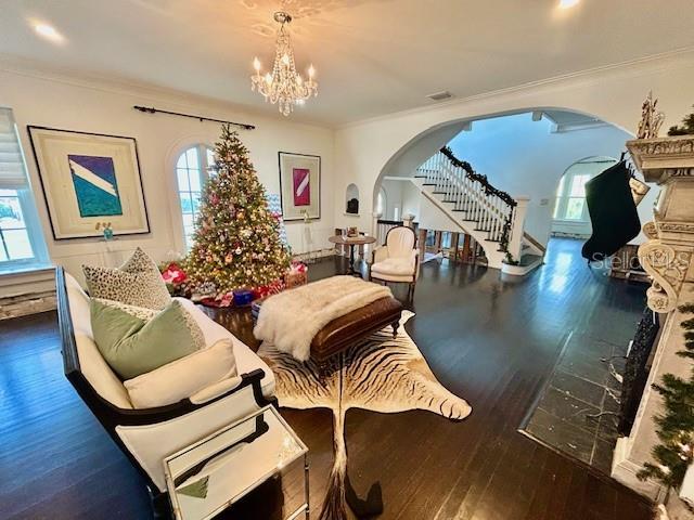 living area with a notable chandelier, dark hardwood / wood-style flooring, and a wealth of natural light