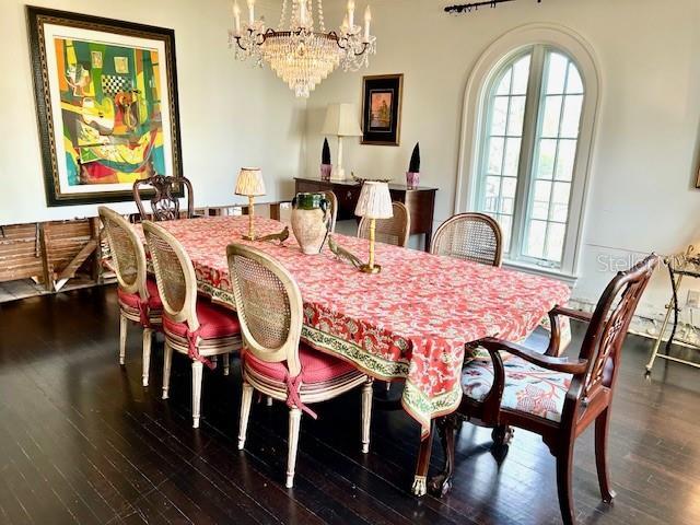 dining space with dark wood-type flooring and a notable chandelier