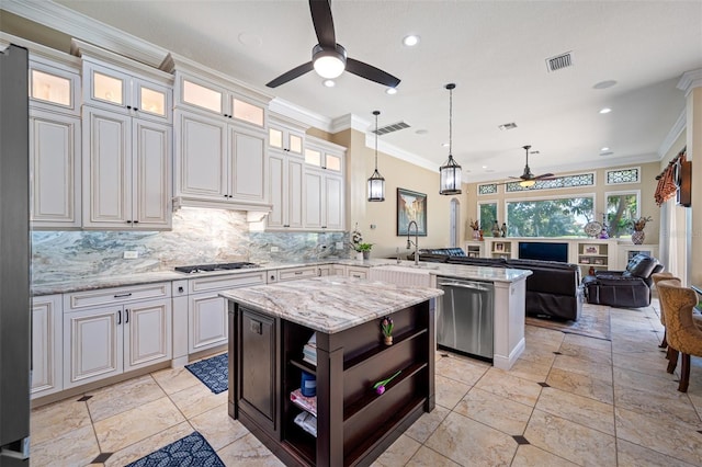 kitchen featuring a center island, crown molding, appliances with stainless steel finishes, decorative light fixtures, and kitchen peninsula