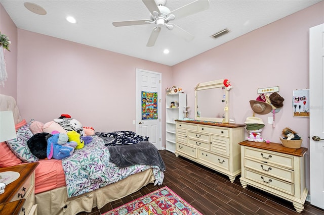 bedroom featuring ceiling fan, dark wood-type flooring, and a textured ceiling