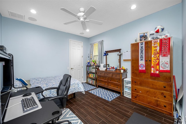 office featuring a textured ceiling, ceiling fan, and dark wood-type flooring