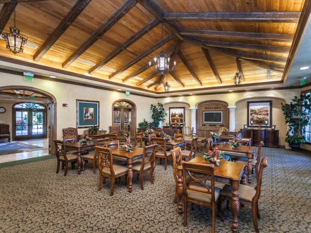 carpeted dining area with vaulted ceiling with beams, a notable chandelier, wood ceiling, and french doors