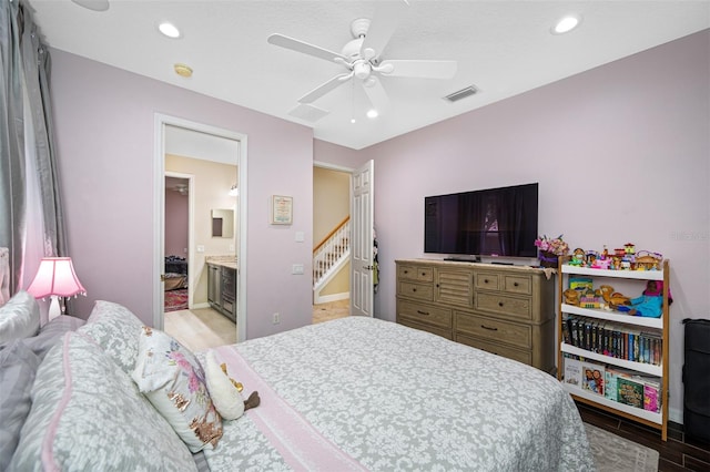 bedroom featuring ceiling fan, light hardwood / wood-style flooring, and ensuite bathroom