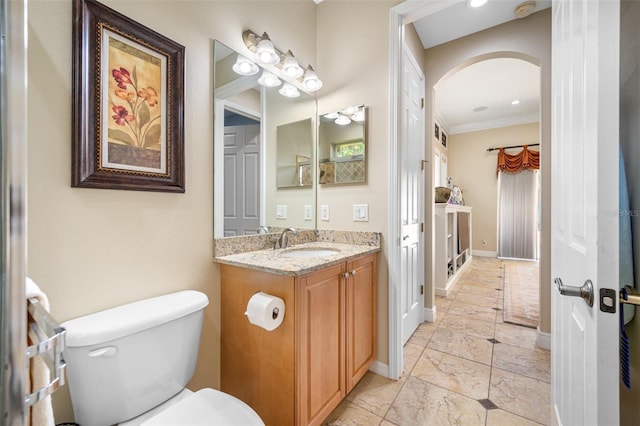 bathroom with vanity, toilet, and ornamental molding