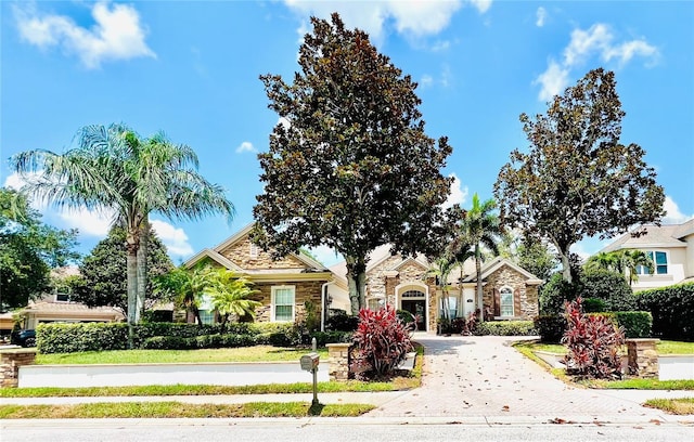 1227 Toscano Dr, Trinity, FL 34655 - obstructed view of property featuring stone siding and driveway