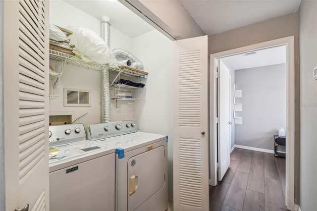 laundry area featuring hookup for a washing machine, washing machine and clothes dryer, and dark hardwood / wood-style flooring