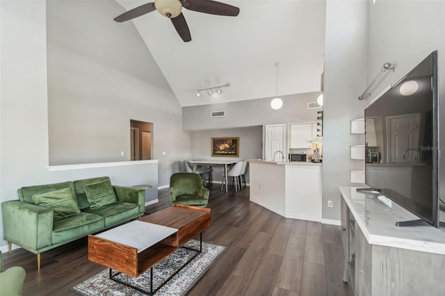 living room featuring high vaulted ceiling, track lighting, dark hardwood / wood-style flooring, and ceiling fan