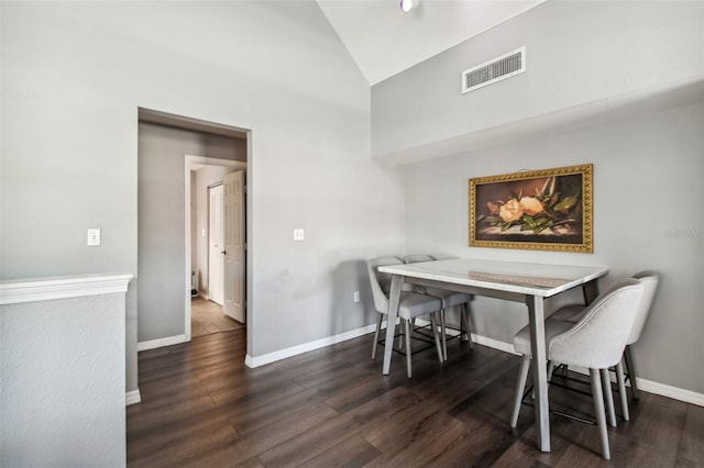 dining room featuring high vaulted ceiling and dark hardwood / wood-style flooring