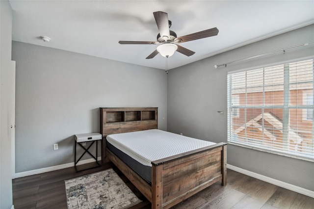 bedroom with dark hardwood / wood-style floors and ceiling fan