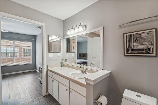 bathroom with hardwood / wood-style flooring, vanity, and toilet